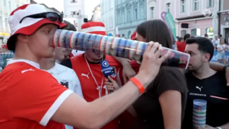 Ösi-Fan trinkt aus riesigem Bierbecher-Stapel während ARD-Live-Schalte