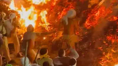 Hindu-Priester läuft barfuß über glühendes Feuer bei Holika-Dahan-Ritual